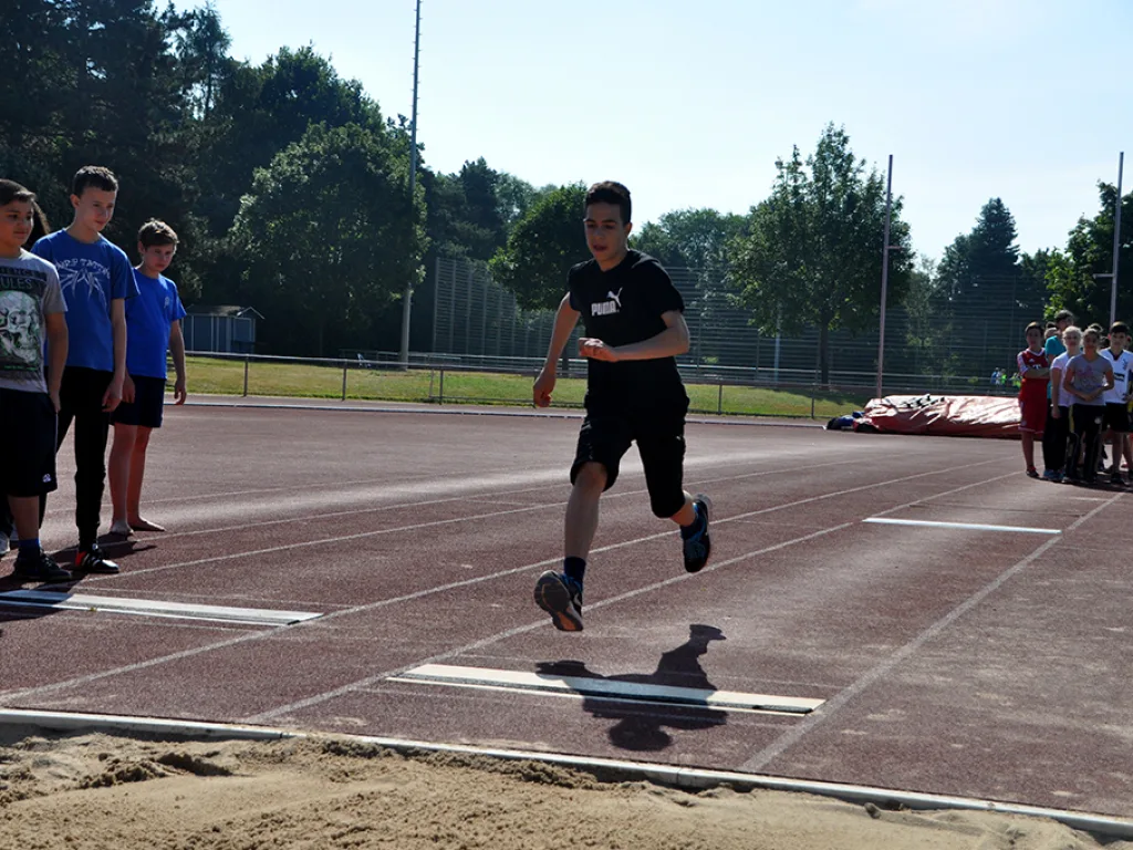 Jugendlicher nimmt Anlauf zum Weitsprung.